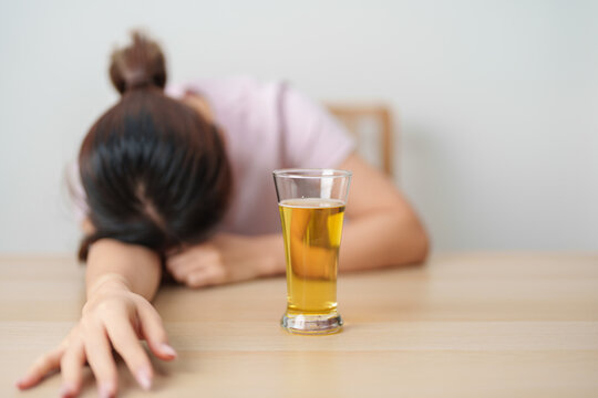 Stressed woman drinking beer alone with problem. Exhausted drunk woman looking stressed and sleepy. Alcohol addiction, Alcoholism, emotional distress and mental health concept