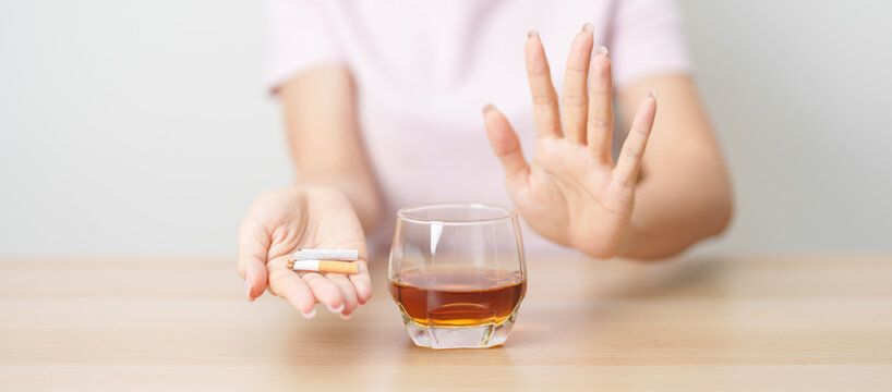 woman hand break and stop gesture to refuse cigarette and glass of Whisky, for say no to alcohol drink and for World No Tobacco Day, quitting smoking to prevent Lung Cancer and stop nicotine addiction