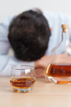 Stressed man drinking cognac alone with problem. Exhausted drunk man looking stressed and sleepy. Alcohol addiction, Alcoholism, emotional distress and mental health concept
