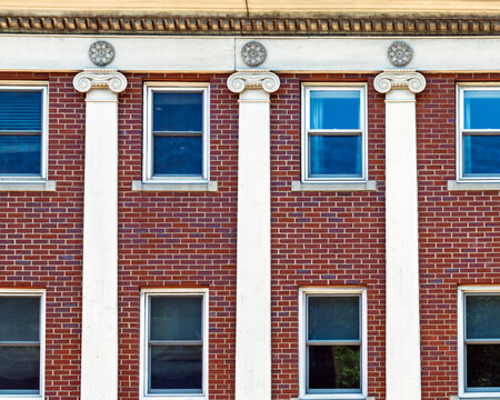 Classic brick building facade featuring white Ionic pilasters and rosettes in Boston, Massachusetts, USA
