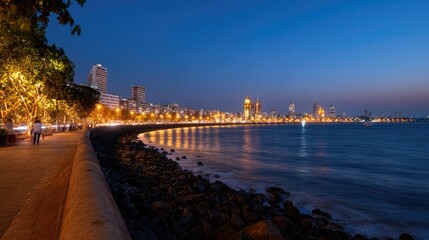 Fototapeta premium Scenic Evening View of a Vibrant Coastal City with Twinkling Lights and the Calm Sea Under a Twilight Sky