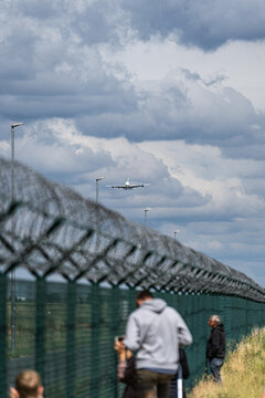 Berlin, Germany - 09 June 2026: View of an Airbus A380 approaching for landing at the ILA Berlin Air Show, with spectators watching from behind a chain-link fence.