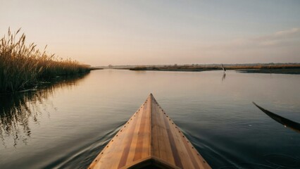 Fototapeta premium Wooden boat bow gliding on calm river at golden hour