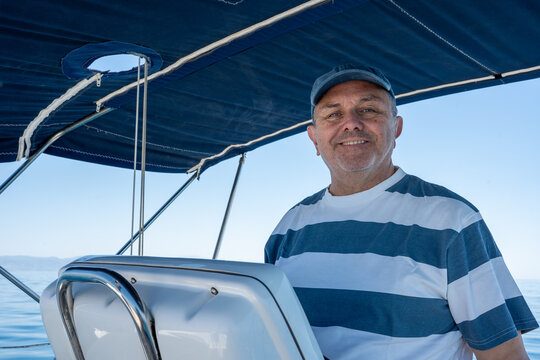 Cheerful man navigatingsailboat on calm blue sea