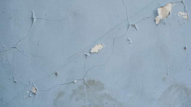 Cracked and peeling blue painted wall with texture