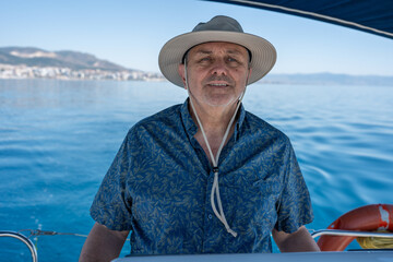 Fototapeta premium Senior man enjoying sailing experience on blue sea