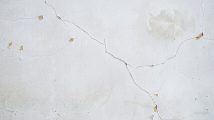 Naklejka premium Cracked and peeling white painted wall with dried leaves