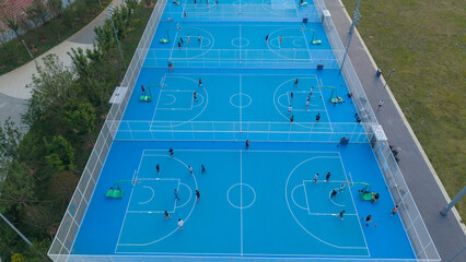 Aerial View of Multiple Outdoor Basketball Courts With Players © Xianshu