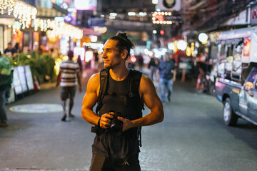 Male photographer enjoying vibrant urban night street © Nazareno