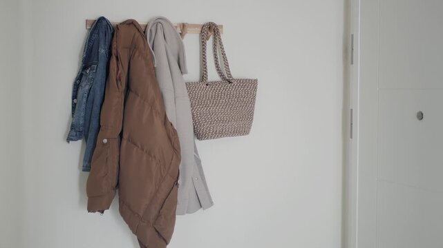 Coat and bag hanging on wall in hallway