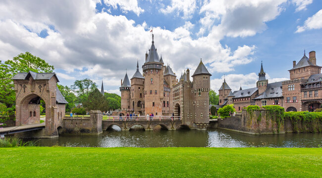 Haarzuilens, Netherlands - 07 June 2026 - Scenic view of the historical Castle de Haar featuring its gothic architecture, a stone bridge, and surrounding water moat.