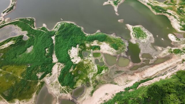Aerial drone footage of a calm lake reflecting clouds and mountains at sunset light. Ideal for nature, travel, environment, wetland, and cinematic landscape projects.