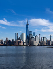 Fototapeta premium New York urban cityscape panorama. New York City towers near river. New York famous skyline with reflection. NYC downtown waterfront view.