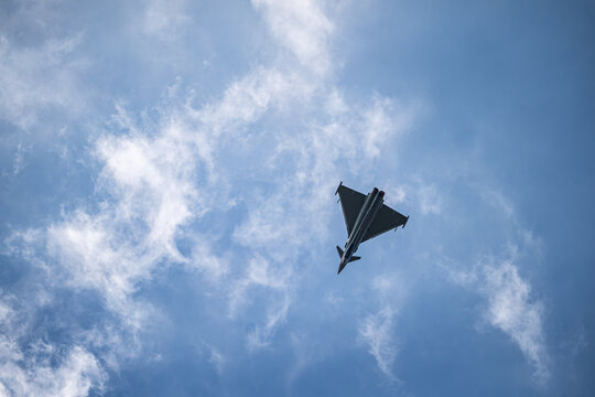 Berlin, Berlin, Germany - 13 June 2026: View of a Eurofighter Typhoon jet performing an aerial display at the ILA Berlin Air Show against a blue sky with scattered clouds.