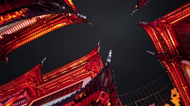 A striking upward view captures the illuminated red roofs of traditional Chinese architecture against the night sky. Ideal for cultural documentaries or architectural studies.