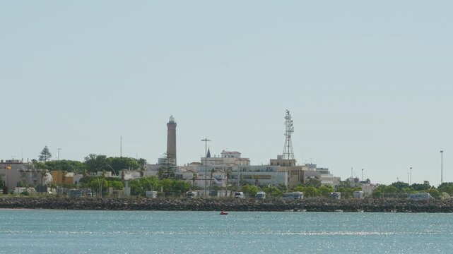 Chipiona on the background with ocean waves on the foreground