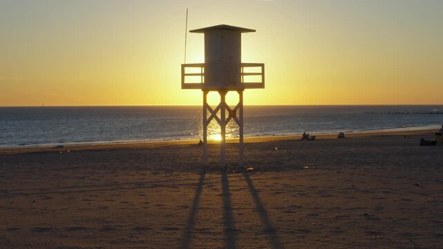 Lifeguard watchtower with sun shining behind it, Chipiona, Cadiz, Spain