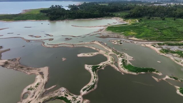 Aerial drone footage of a calm lake reflecting clouds and mountains at sunset light. Ideal for nature, travel, environment, wetland, and cinematic landscape projects.