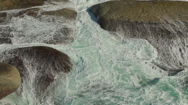 Pullback aerial drone shot over foaming surf, Millers Point, Western Cape, South Africa