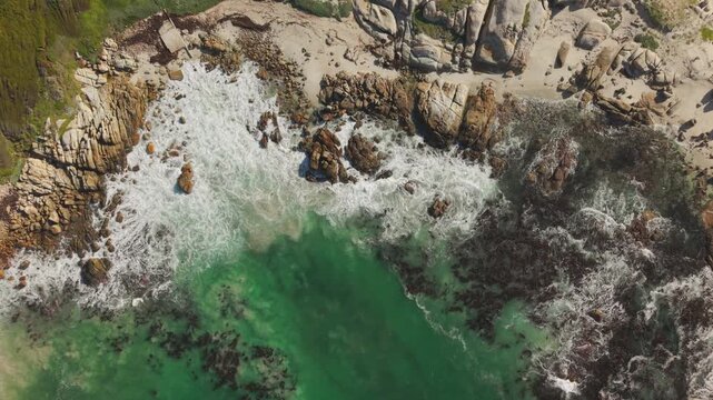 Top down aerial pan over rocky cove and beach, Millers Point, Western Cape, South Africa