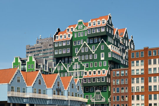 Zaandam, Netherlands - 16 June 2026: View of the iconic Inntel Hotels Zaandam, a unique building featuring stacked traditional green Dutch house facades under a clear blue sky.
