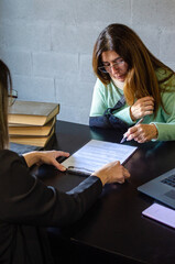 Obraz premium Injured woman signing legal form during consultation with professional attorney