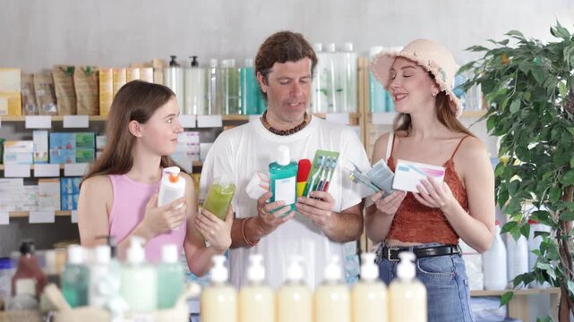 Father, mother and daughter choose different products together in pharmacy. High quality 4k footage