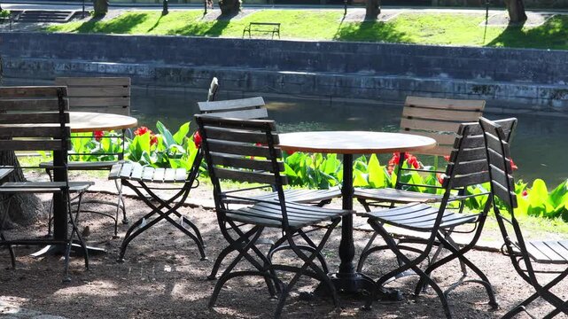 Scenic lake view with picnic tables and lush trees
