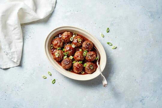 gourmet glazed meatballs with sauce and green onion garnish food photography top view dish