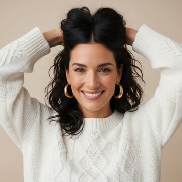 Smiling woman in white sweater with hands in hair