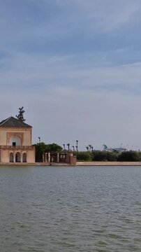 Airplane approaching Marrakech Menara Airport behind historic Menara Gardens in Morocco