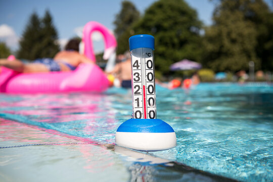 Sommer:  ein Poolthermometer in einem Freibad zeigt eine Wassertemperatur von 27 Grad Celsius an.