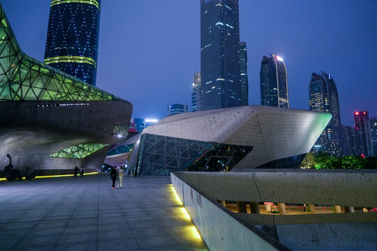 Guangzhou, Guangdong Province, China - 24 February 2024: View of Guangzhou Opera House with its futuristic architecture illuminated at night, surrounded by modern skyscrapers.