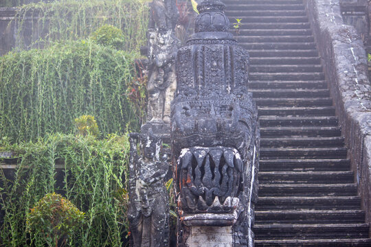 Carved stone steps rising into mist beside hanging vines at Pura Lempuyang, Gates of Heaven, Karangasem, East Bali, Indonesia.