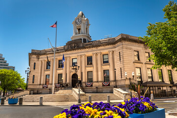 Naklejka premium Historic stone town hall building with a clock tower and columns in