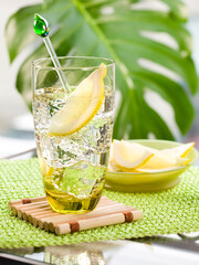 Naklejka premium Refreshing iced drink with a lemon slice and a glass swizzle stick on
