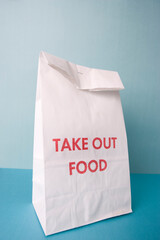 Fototapeta premium Plain white paper takeout bag with red text on a blue background