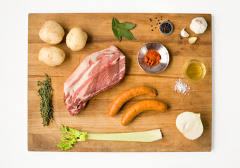 Naklejka premium Top view of raw pork meat sausages and fresh vegetables arranged on a