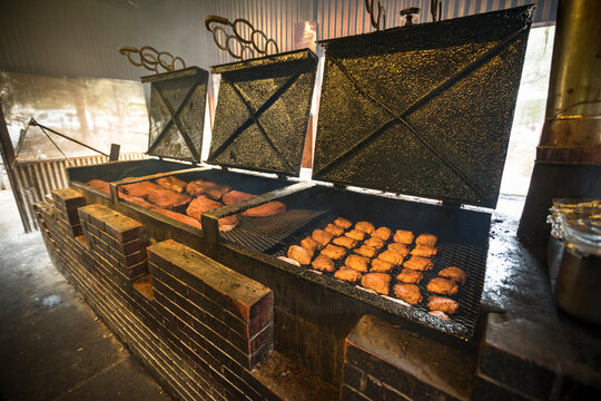 Large brick barbecue pit filled with smoking meats