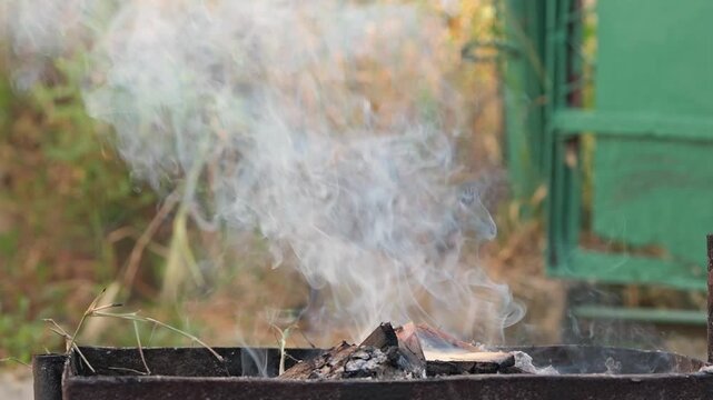 Barbecue grill smoke rising from burning coals