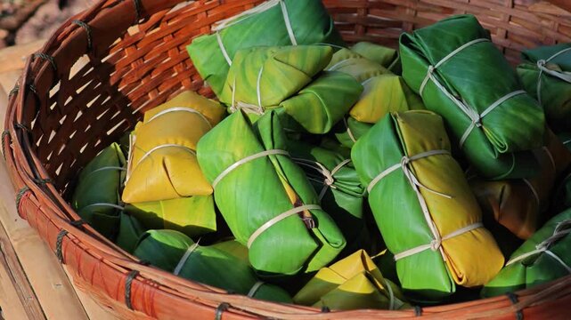 Thai dessert made of sticky rice, banana and coconut milk, all wrapped in banana leaves.
