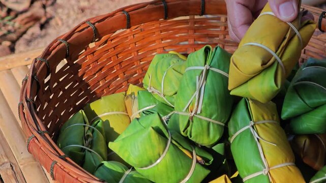 Thai dessert made of sticky rice, banana and coconut milk, all wrapped in banana leaves.
