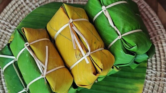 Thai dessert made of sticky rice, banana and coconut milk, all wrapped in banana leaves.
