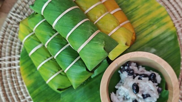 Thai dessert made of sticky rice, banana and coconut milk, all wrapped in banana leaves.