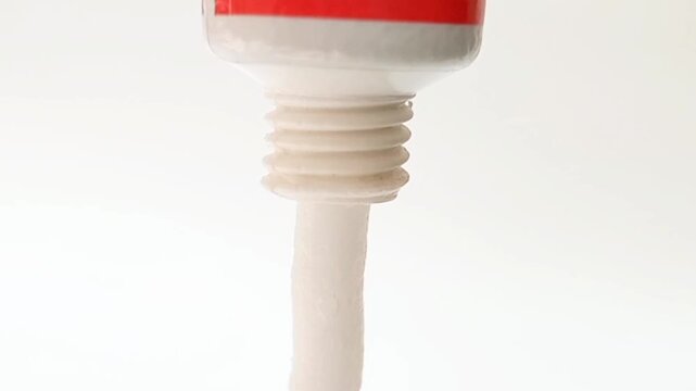 White cream coming out of a tube on white background, medical, cosmetic or skincare product. close up