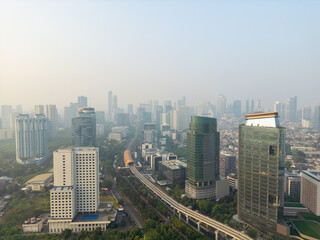 Obraz premium Aerial View of Modern Cityscape with Skyscrapers and LRT Train Track Infrastructure in Morning Haze
