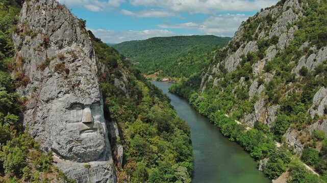 Aerial view of stone carved statue portrait of ancient dacian king Decebal. Sculpture located on shore of Danube River, Romania, 4k