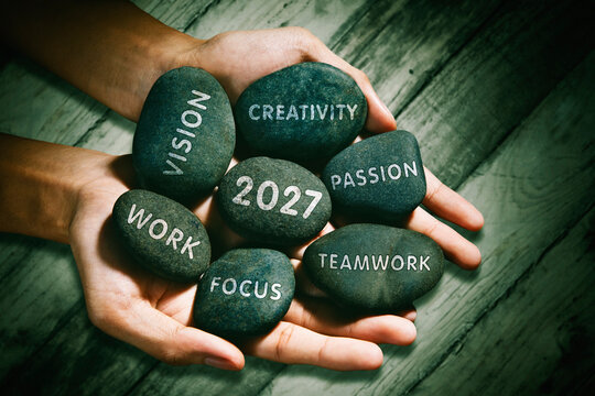 Hands Holding Motivational Pebbles with Year 2027 and Core Values