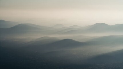 Obraz premium Mountains covered in mist during early morning hours in a hilly region