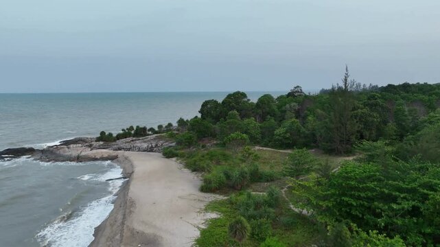 Aerial drone view of the tropical sandy beach and rocky coastline near Puri Tri Agung temple in Bangka Island, Indonesia. Scenic landscape of beautiful Indonesian tourist destinations
